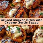Appetizing pieces of chicken with a crispy crust, topped with a creamy garlic sauce, on a white plate with herbs and lemon for decoration.