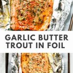 Baked trout in foil, drizzled with garlic butter, with a golden crust and herbs, served on a wooden board, with a slice of lemon and fresh herbs nearby.
