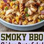 Smoked BBQ chicken and pasta salad, garnished with fresh herbs and served in a deep bowl.